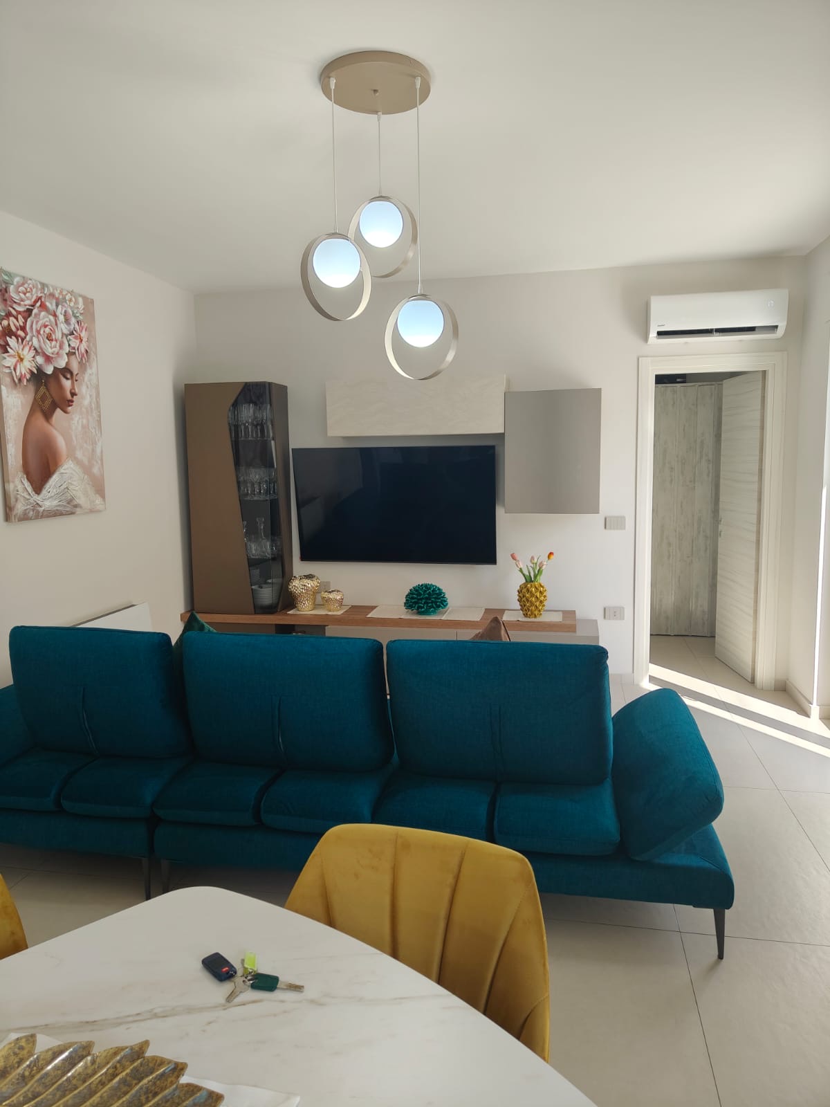 Open space con divano angolare turchese, realizzazione Molitierno Arredamenti