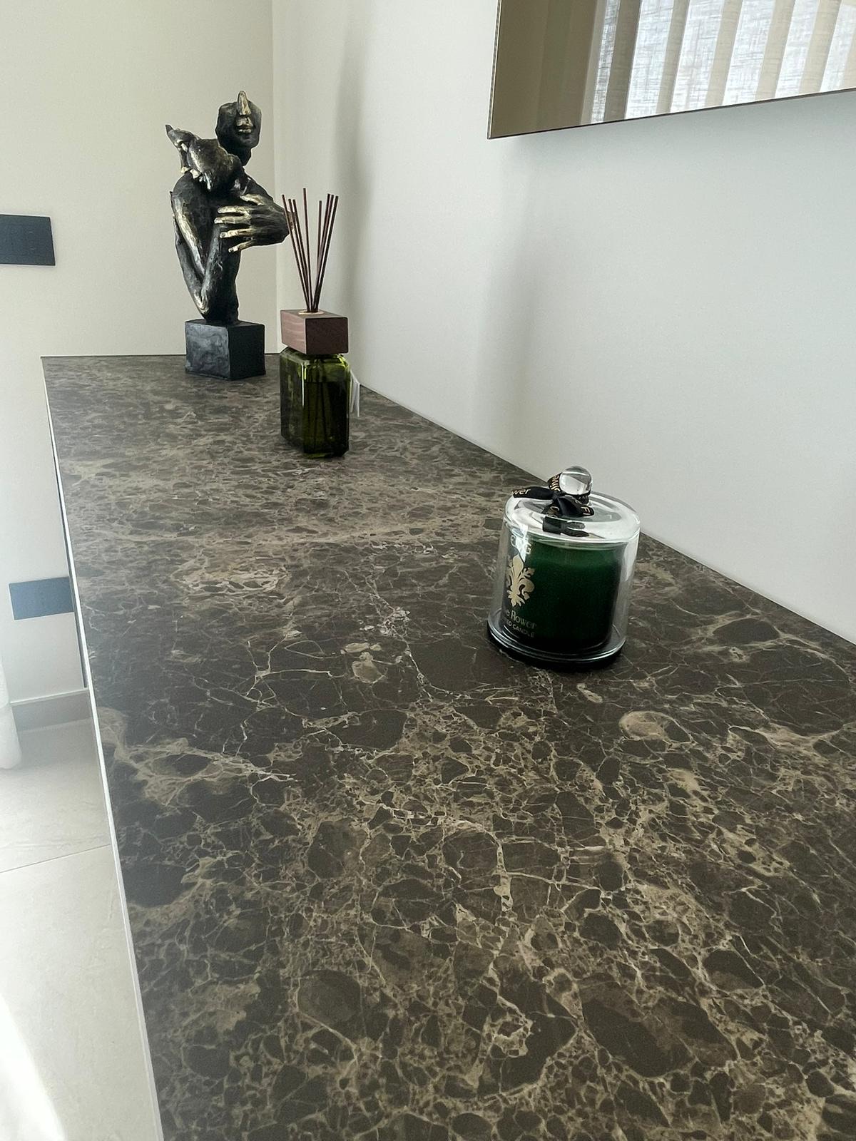Piano in marmo scuro con oggetti decorativi, realizzazione Molitierno Arredamenti